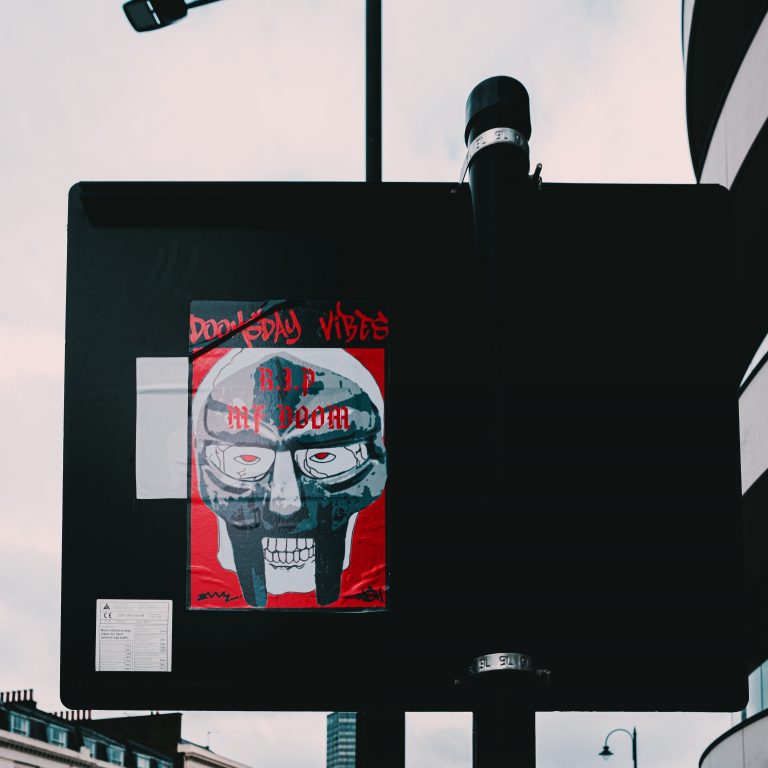 a poster of MF Doom in a mask with the words doomsday vibes.
