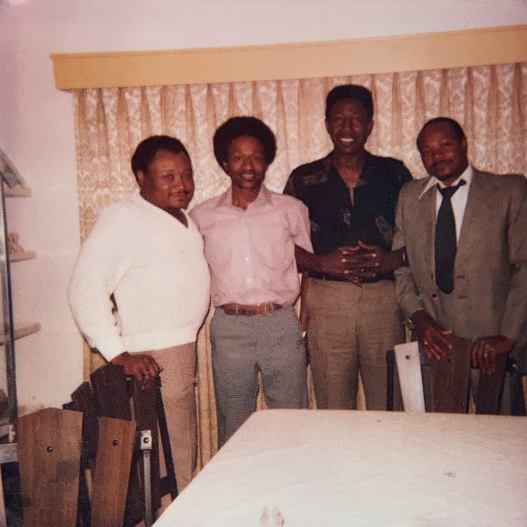 Four older Black men standing in room