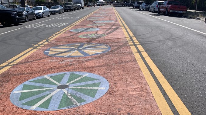 Street with orange bike lane with colorful wheels