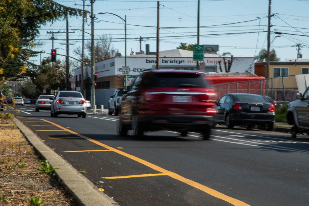 A red dodge is a blur as it drives by on a street