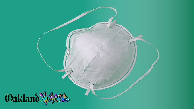 Photo of a white n95 grade face mask against a mint green background with the Oakland Voices logo in the lower left corner.
