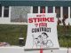A canvas sign on a stick that says "strike for a fair contract"