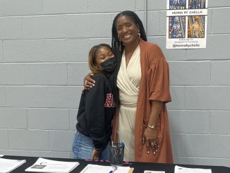A young Black girl hugs a Black woman at an event