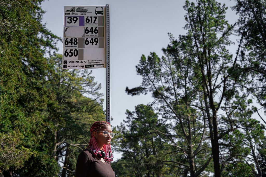 An African American girl waits at a bus stop