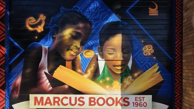 a colorful mural depicting African Americans and the words "Marcus Books est. 1960" in red letters