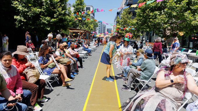 an outdoor catwalk with an audience in folding chairs outside