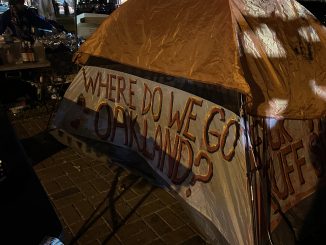 Orange and white tent with letters asking, "Where do we go, Oakland?"