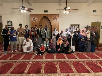 a group of people in a mosque holding copies of a book