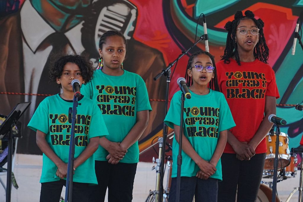 Four youth wearing “Young, Gifted, and Black” shirts perform during the Malcolm X JazzArts Festival in Oakland.